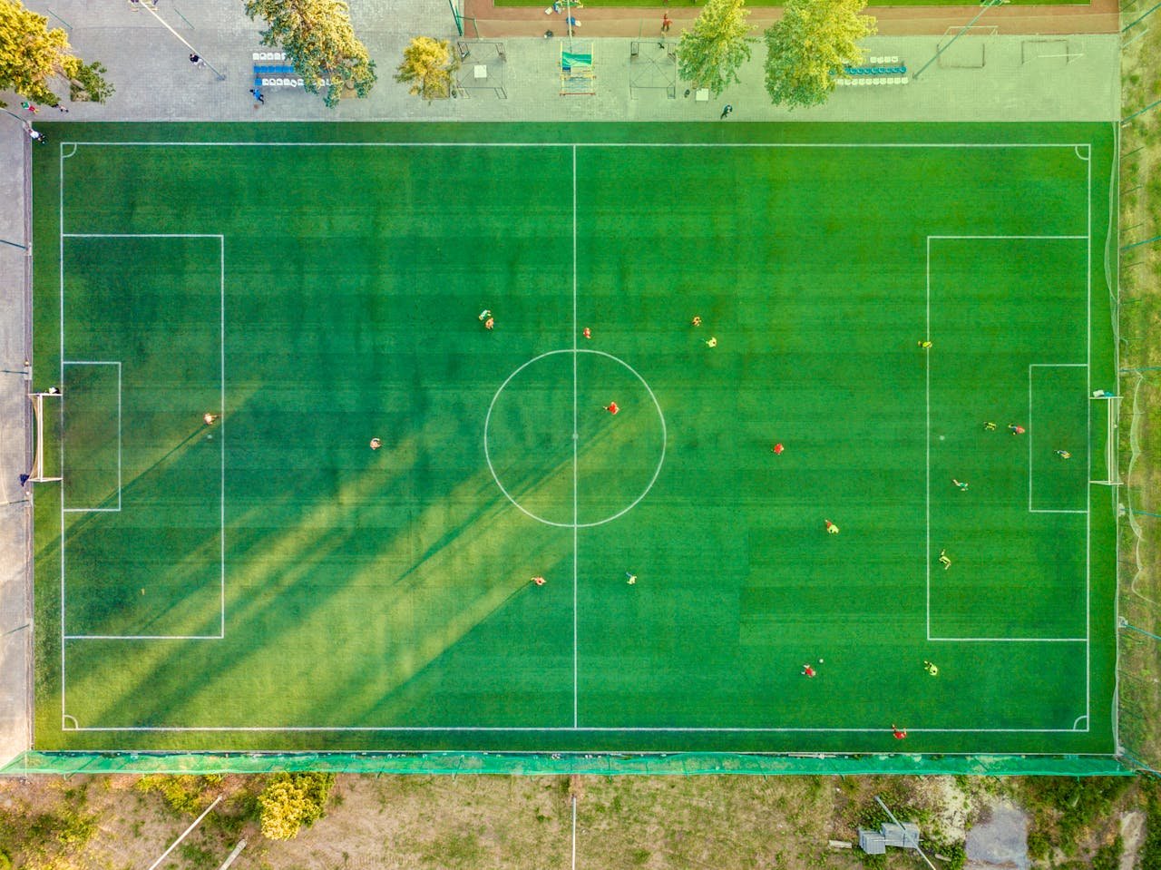 Aerial shot of a soccer game with players on a vibrant green field.